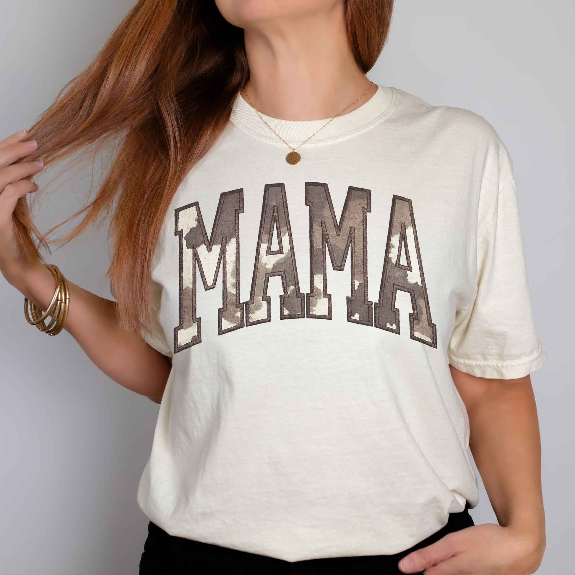 woman wearing embroidered cow print mama shirt with western applique lettering
