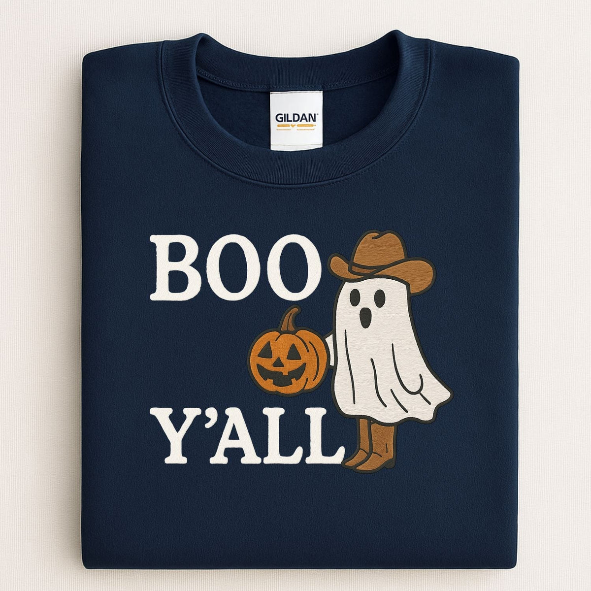 Folded Navy Gildan crewneck showing the embroidered cowboy ghost design