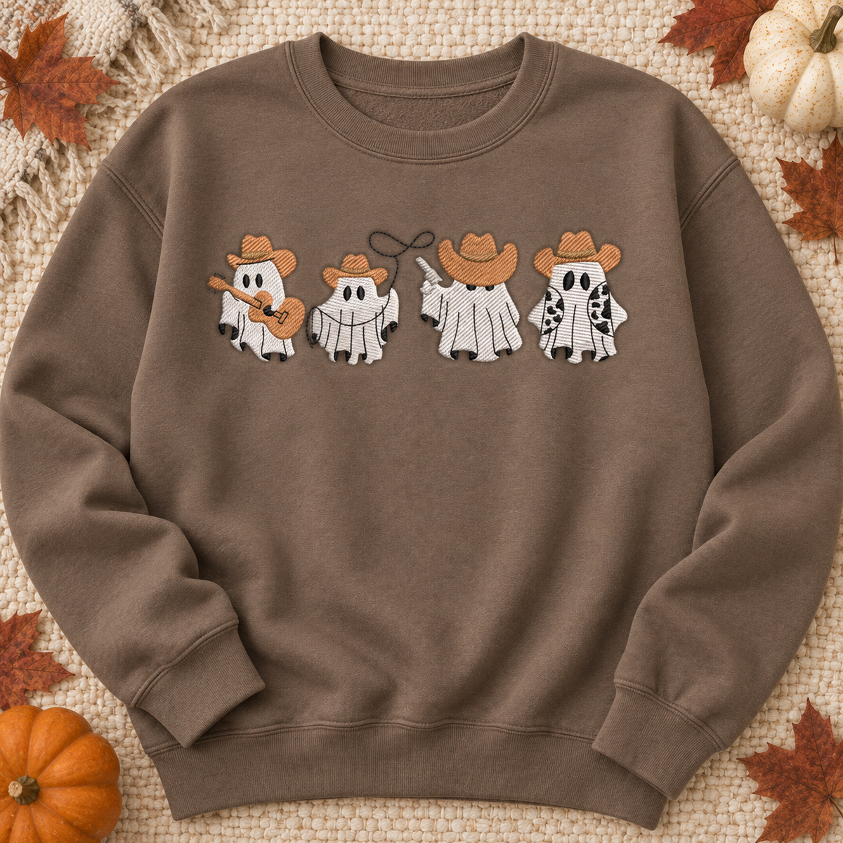 Brown Savanna embroidered cowboy ghosts sweatshirt flat lay with pumpkins and autumn leaves