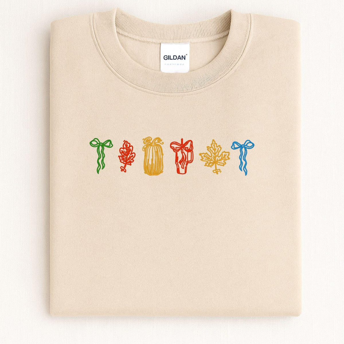 Sand cozy fall embroidered crewneck folded on a light background