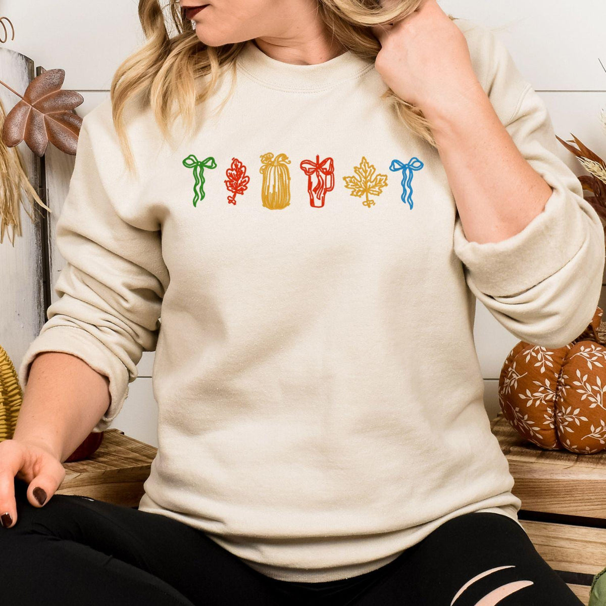 Sand sweatshirt modeled with colorful pumpkin bow and leaf embroidery