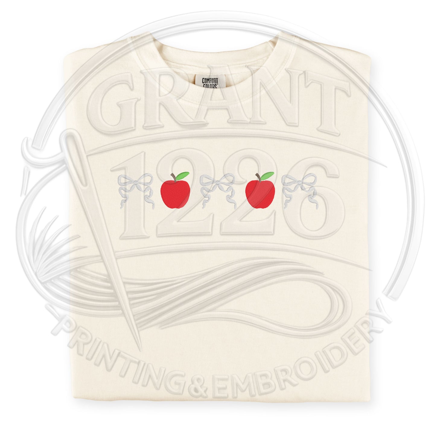 Ivory embroidered teacher shirt with red apples and coquette bow design on Comfort Colors tee