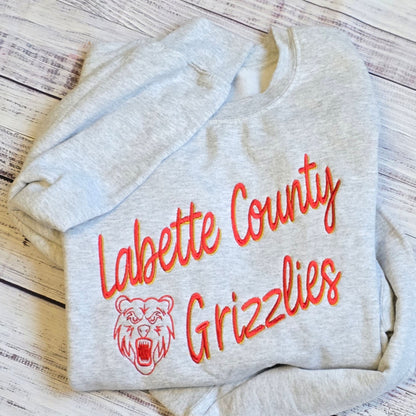 Custom shadow embroidered sweatshirt on ash gray crewneck featuring sports team sample design. 