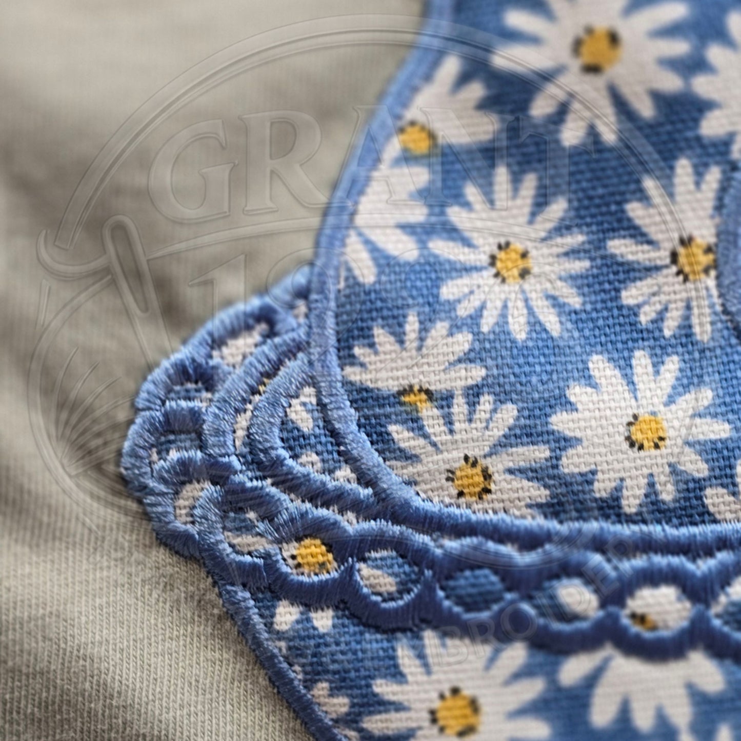 Close up detail of blue daisy chicken applique embroidery stitching
