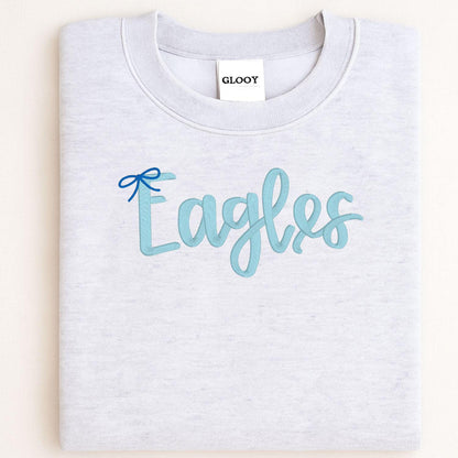 Sport gray sweatshirt with light blue Eagles script and bow embroidery folded flat
