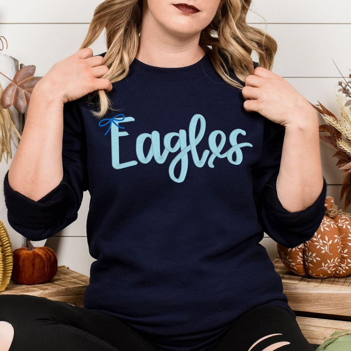 Sand Eagles script embroidered crewneck modeled indoors