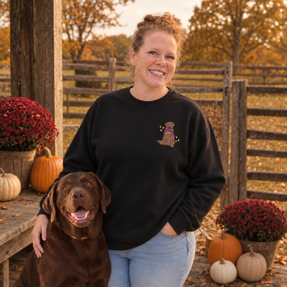 Woman with chocolate Labrador wearing a black embroidered Halloween Lab sweatshirt on a fall porch