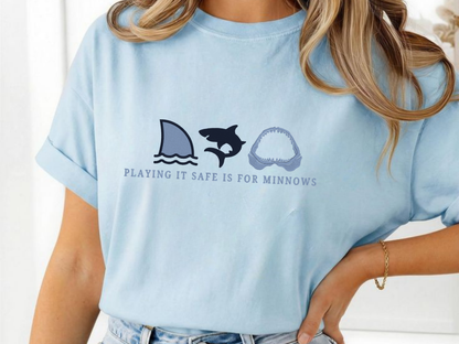 Light blue t-shirt with shark graphic and text worn by a person