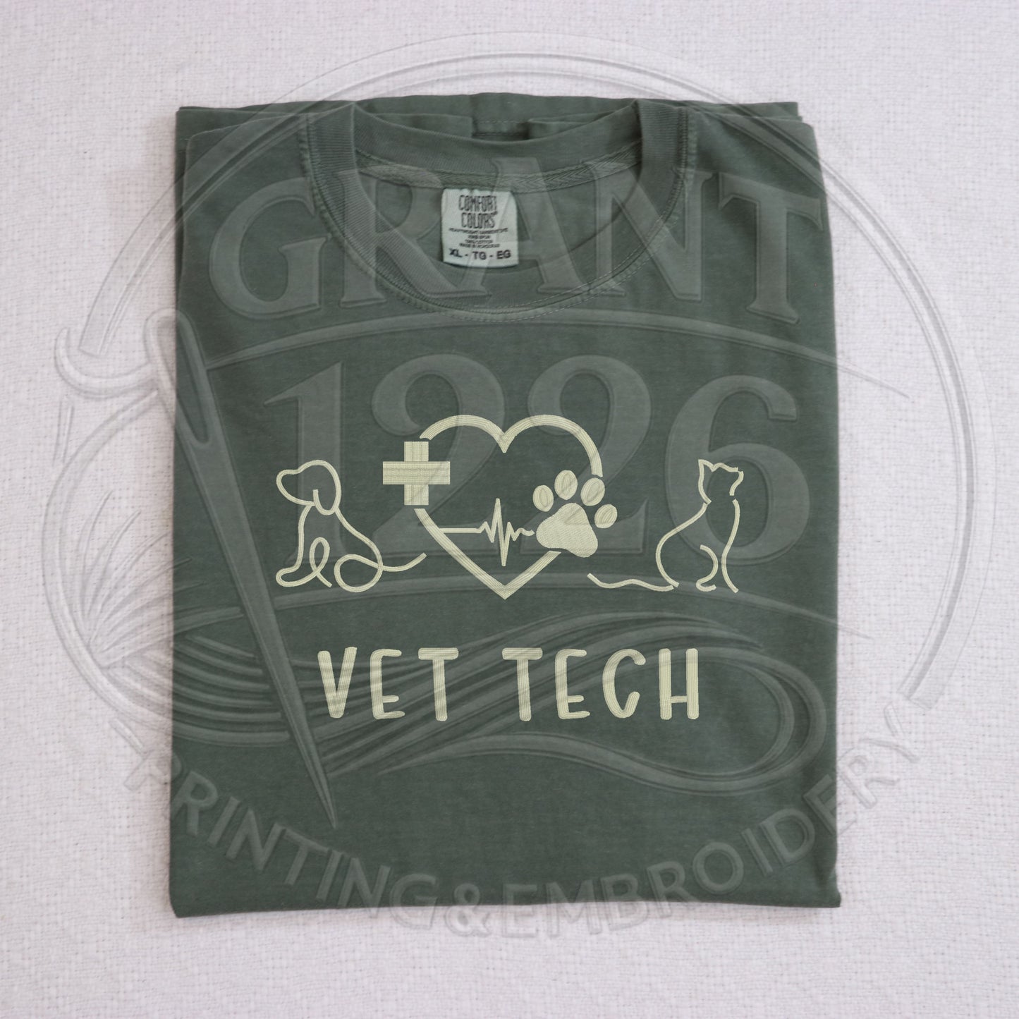 Green Comfort Colors embroidered vet tech shirt flat lay