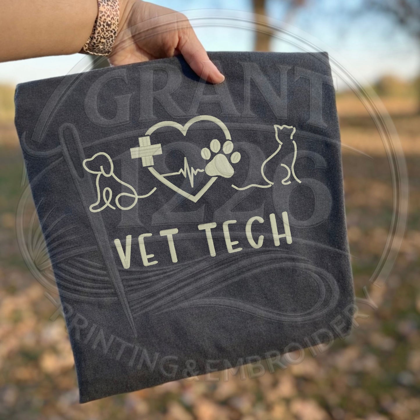 Dark gray embroidered veterinary technician Comfort Colors shirt outdoors