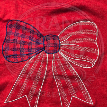 Close-up of embroidered red, white, and blue gingham bow on red kids shirt