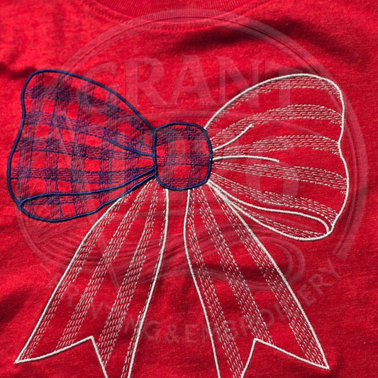 Close-up of embroidered red, white, and blue gingham bow on red kids shirt