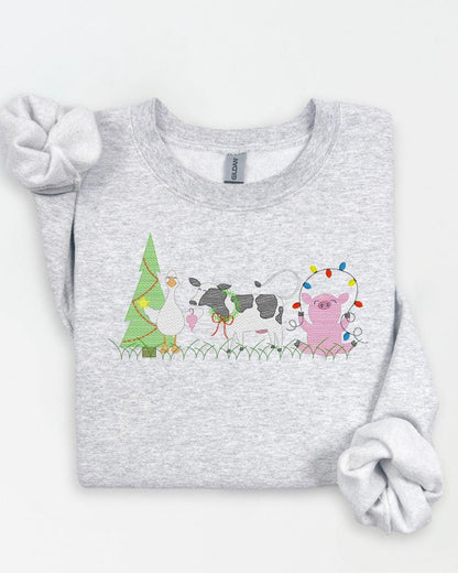 Farm animal embroidered Christmas sweatshirt styled in a rustic holiday flat lay.
