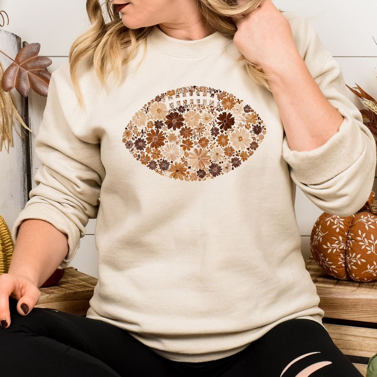 Sand Gildan 18000 floral football sweatshirt in a fall game day setting