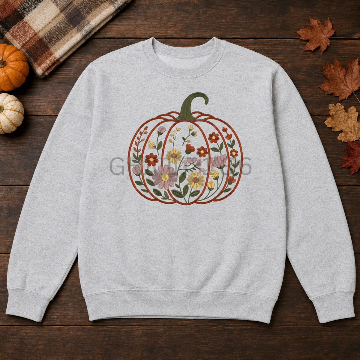 Ash Gildan Softstyle sweatshirt with centered floral garden pumpkin embroidery in an autumn flat lay