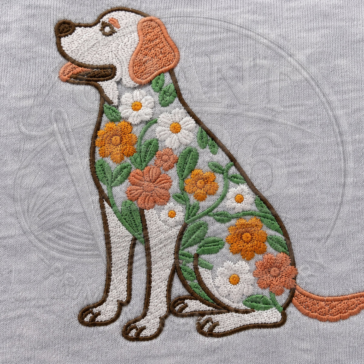 Close-up of floral Labrador Retriever embroidery with orange flowers, white daisies, green leaves and brown stitched outline.