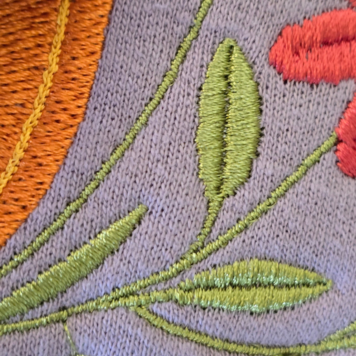 Close-up of orange pumpkin and wildflower embroidery stitching