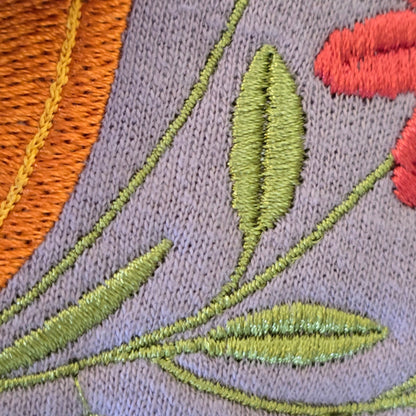 Close-up of orange pumpkin and wildflower embroidery stitching