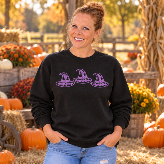 Woman wearing black Floral Witch Hat Trio embroidered sweatshirt with lavender thread
