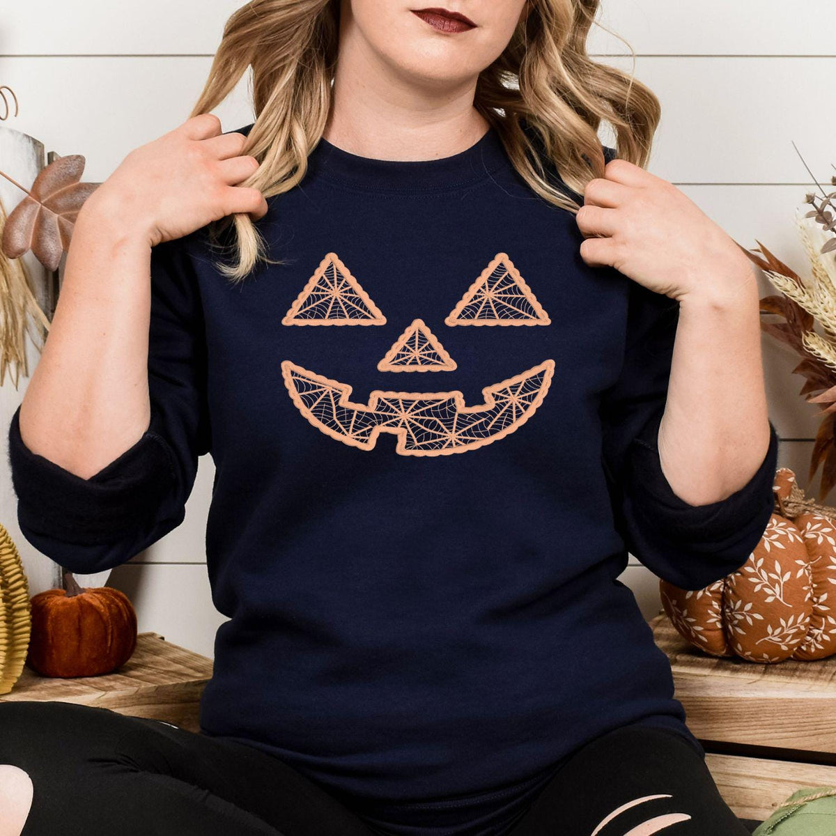 Front view of navy geometric jack-o-lantern embroidered sweatshirt