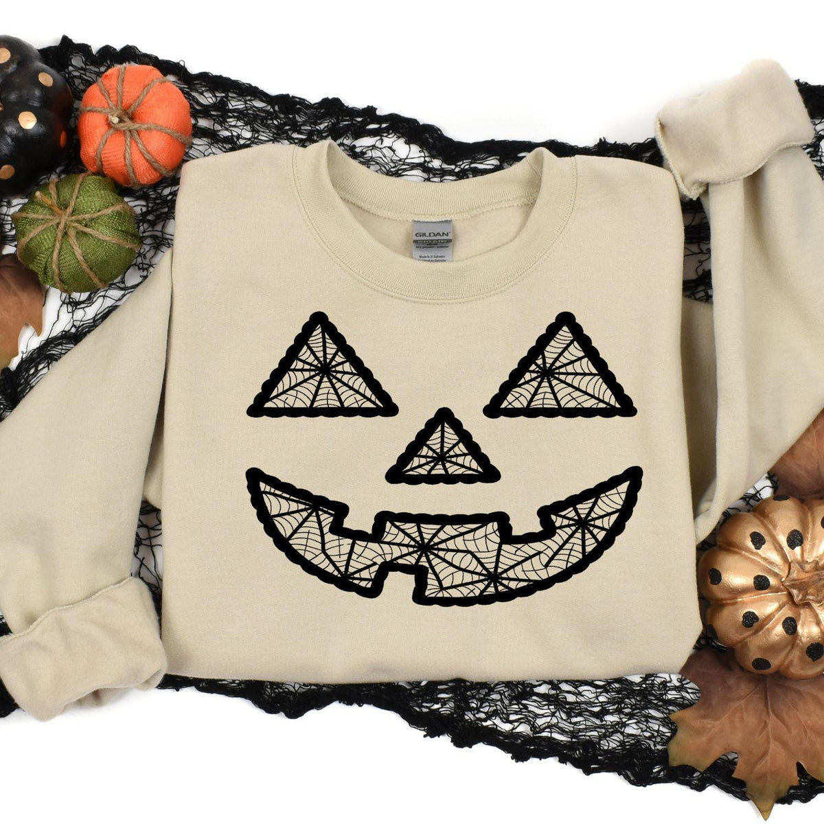 Sand geometric pumpkin face sweatshirt styled in a Halloween flat lay