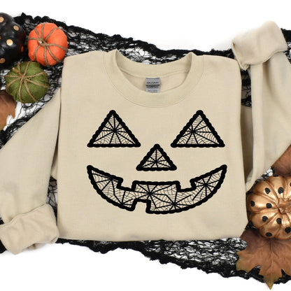 Sand geometric pumpkin face sweatshirt styled in a Halloween flat lay