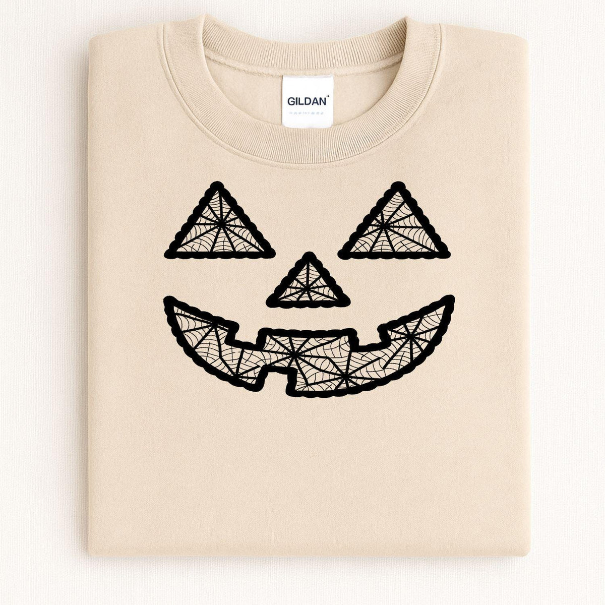 Folded sand crewneck with black geometric jack-o-lantern embroidery