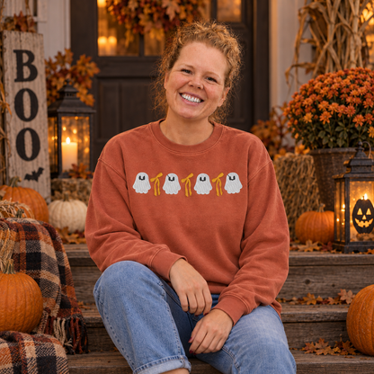 Samantha modeling a Terracotta ghost and bow embroidered sweatshirt on a Halloween porch
