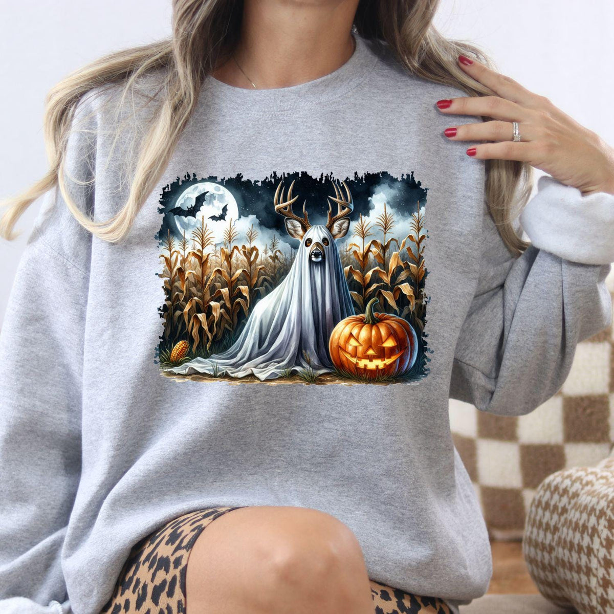 Sport gray ghost deer pumpkin and moon sweatshirt modeled indoors