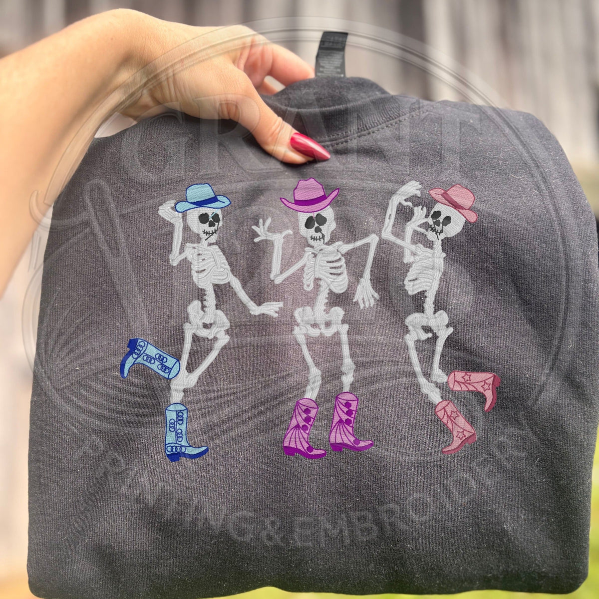 Black Gildan Heavy Blend sweatshirt with embroidered dancing cowgirl skeletons in colorful hats and boots