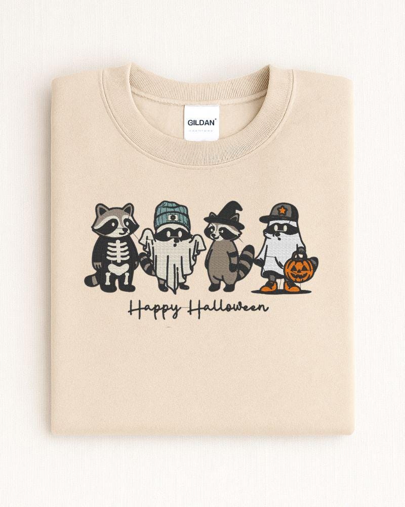 Sand Gildan Heavy Blend embroidered Halloween sweatshirt with four costumed raccoons and Happy Halloween text
