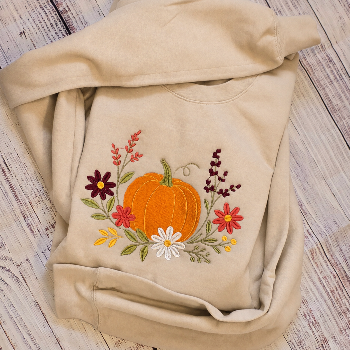 Sand floral pumpkin embroidered Gildan Softstyle sweatshirt folded view