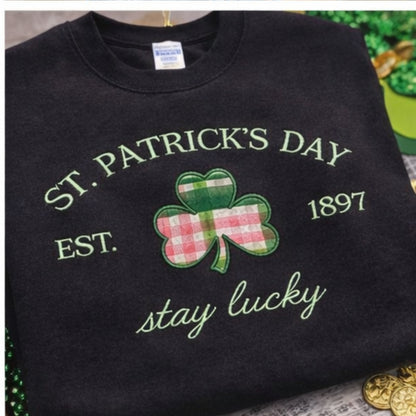 Black sweatshirt with St. Patrick's Day design featuring a shamrock and text on a textured surface.