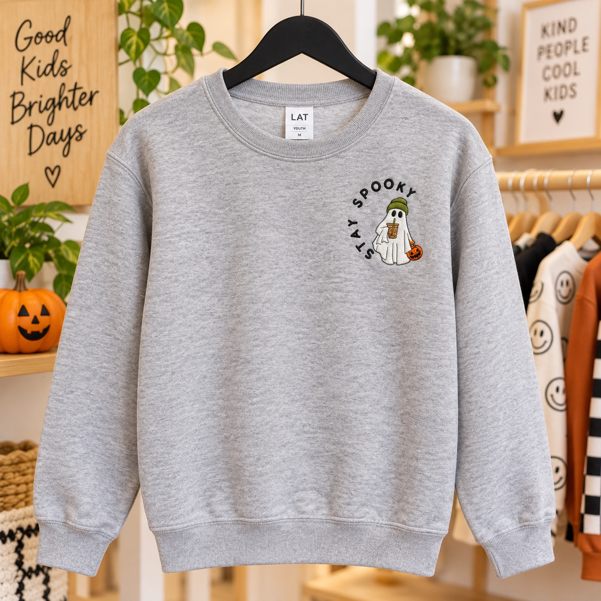 Girl wearing a Heather LAT sweatshirt with Stay Spooky Halloween ghost embroidery on the left chest