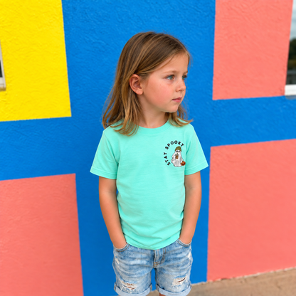 Girl wearing a Saltwater LAT shirt with small Stay Spooky coffee ghost embroidery on the left chest