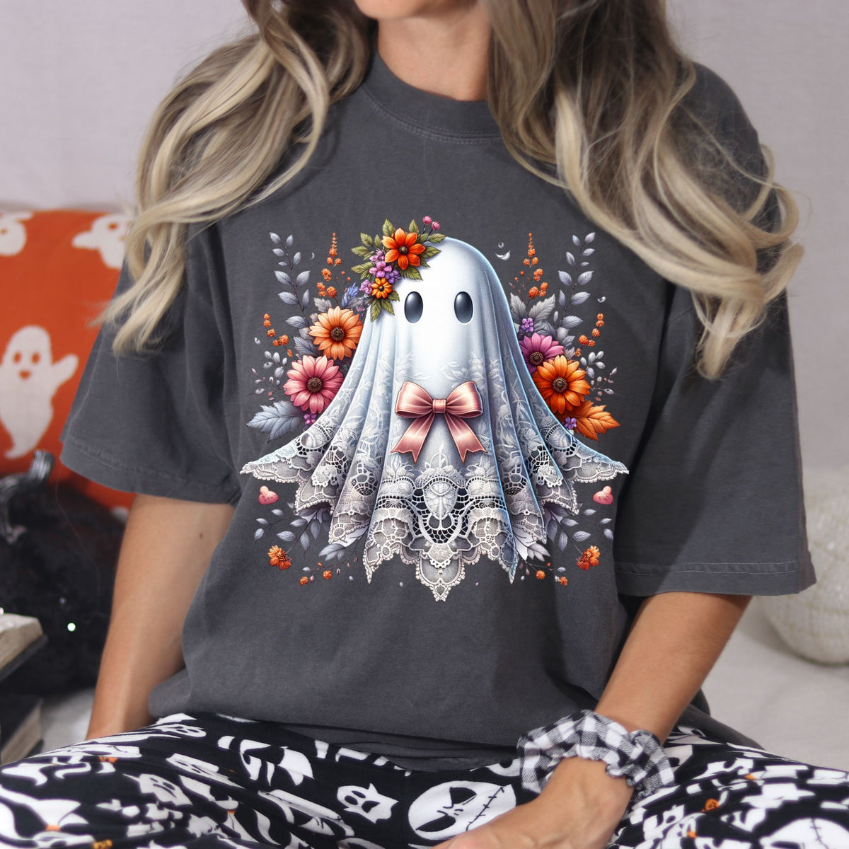 Lifestyle view of a floral coquette ghost graphic on a Pepper Comfort Colors Halloween tee