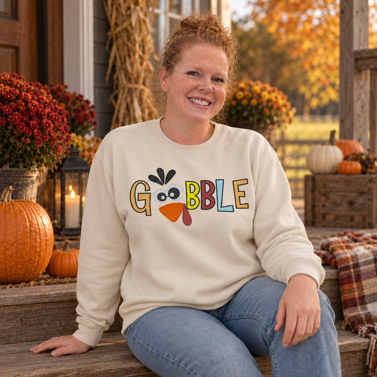 Samantha wearing a Sand Gobble turkey embroidered sweatshirt on a fall porch