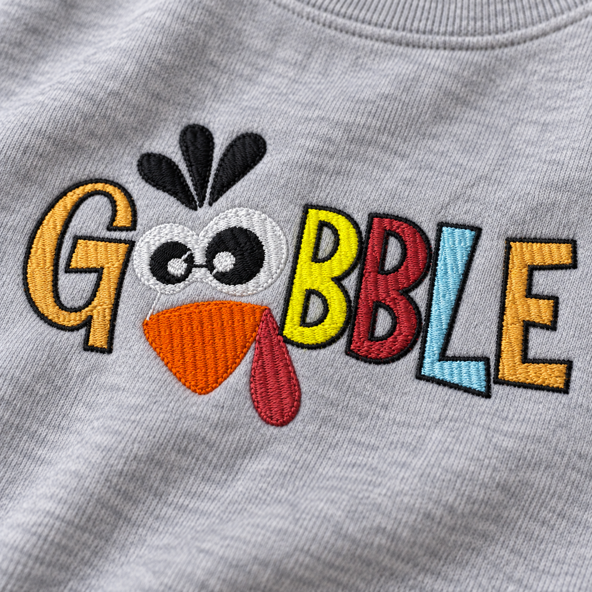 Close-up of colorful Gobble turkey embroidery stitched on Sport Grey sweatshirt fleece