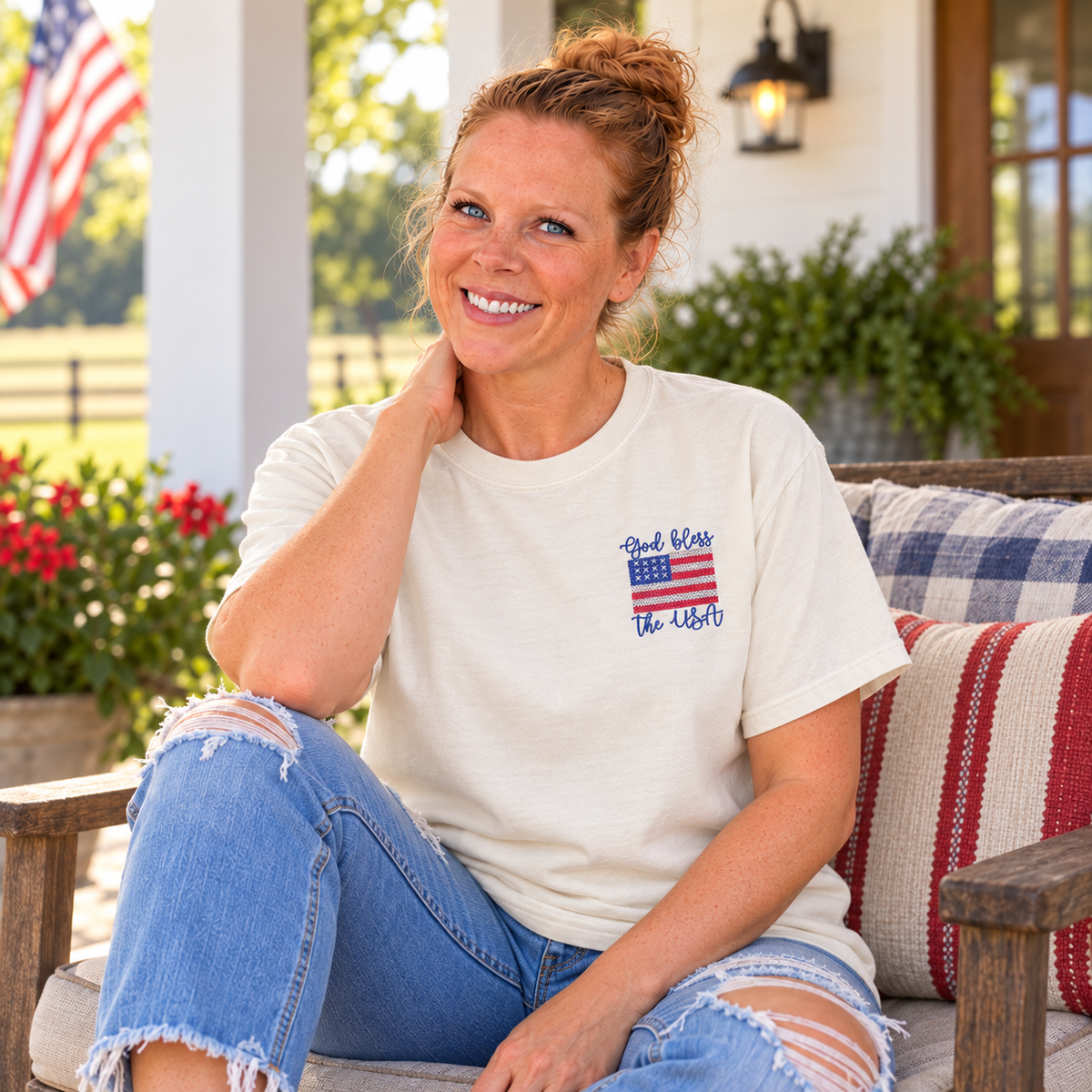 Samantha seated in an Ivory Comfort Colors tee with God Bless the USA left-chest embroidery