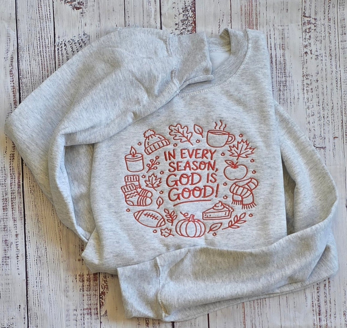 Ash God Is Good embroidered sweatshirt with rust fall icons shown from the front