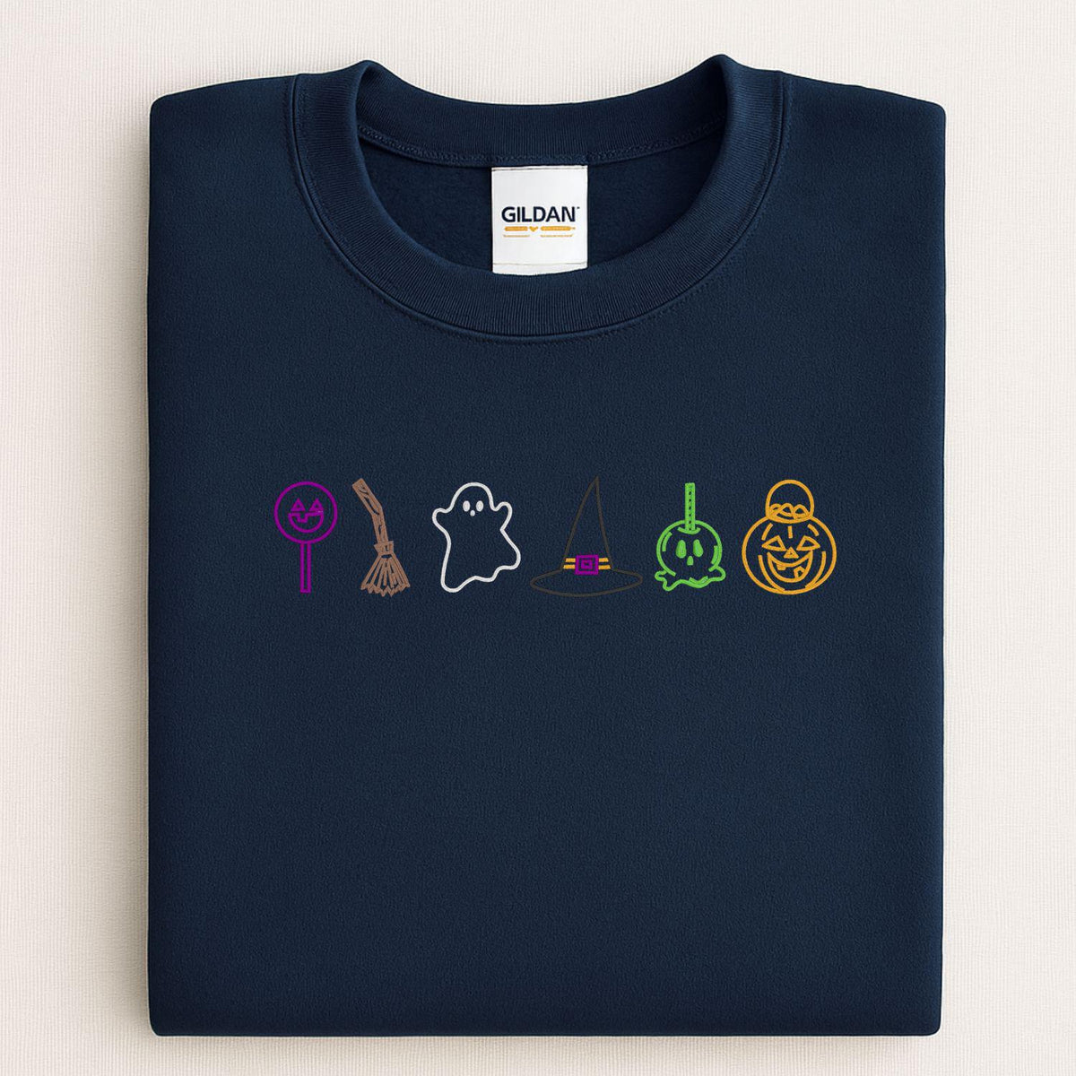 Navy sweatshirt with embroidered Halloween candy ghost witch hat and pumpkin icons folded flat