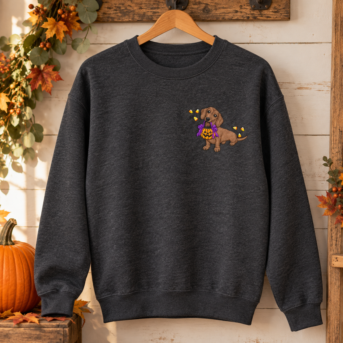 Dark Heather Halloween dachshund embroidered sweatshirt hanging with fall decor