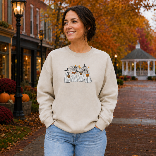 Sand Gildan Softstyle Halloween dog ghost embroidered sweatshirt on woman in a fall town