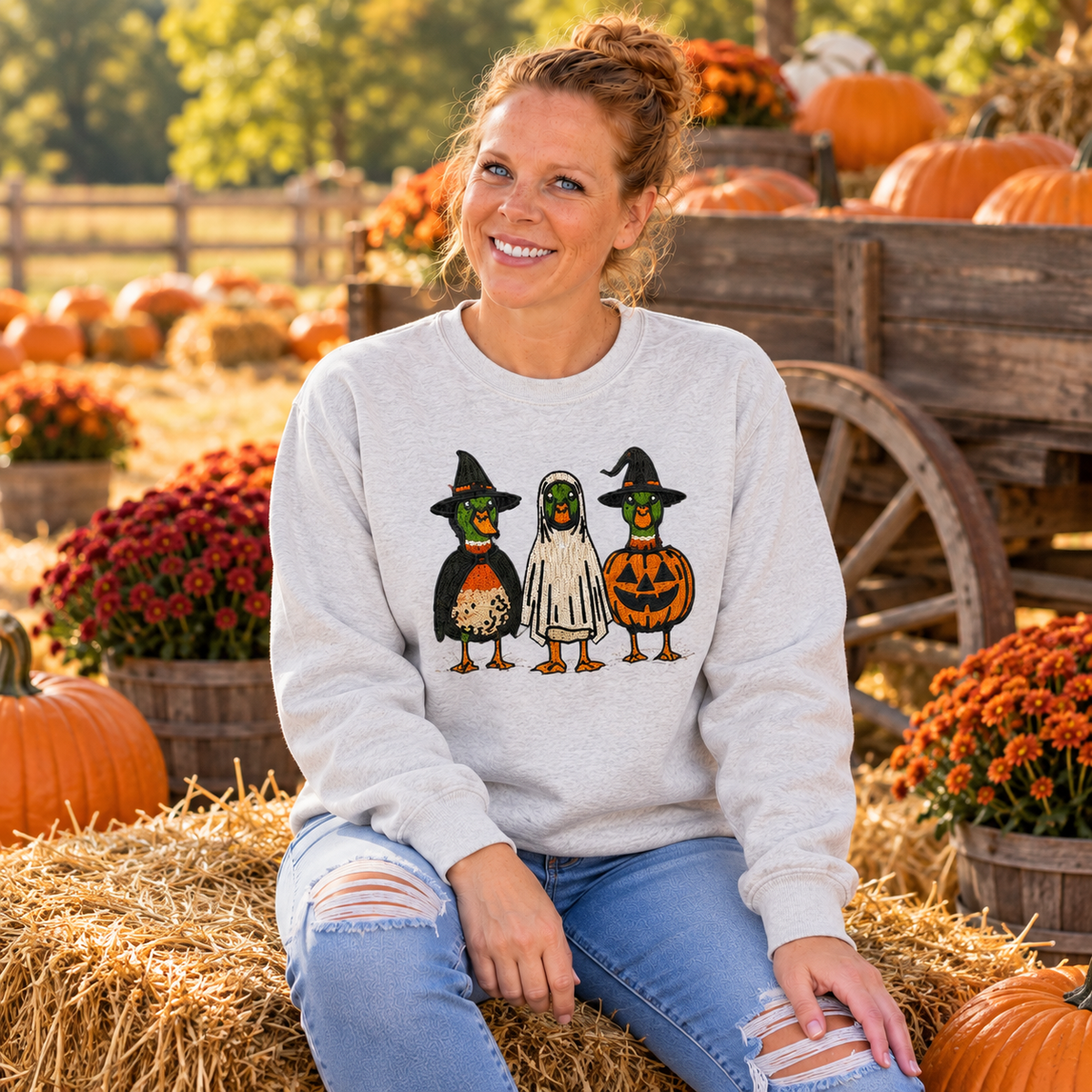 Woman wearing Ash Halloween Duck embroidered sweatshirt at a pumpkin wagon