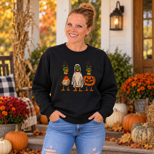 Woman wearing Black Halloween Duck embroidered sweatshirt on a fall porch