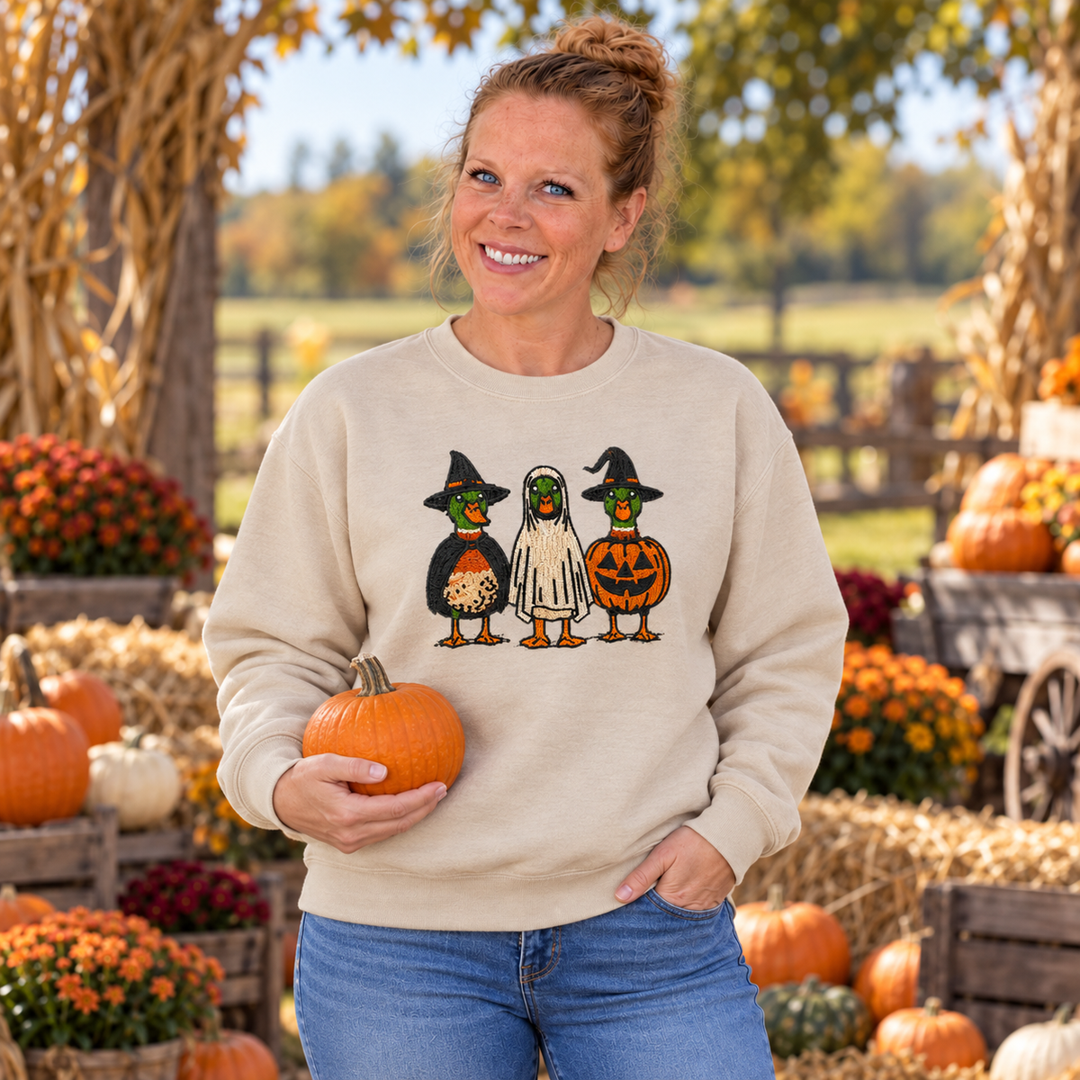 Woman wearing Sand Halloween Duck embroidered sweatshirt at a pumpkin patch