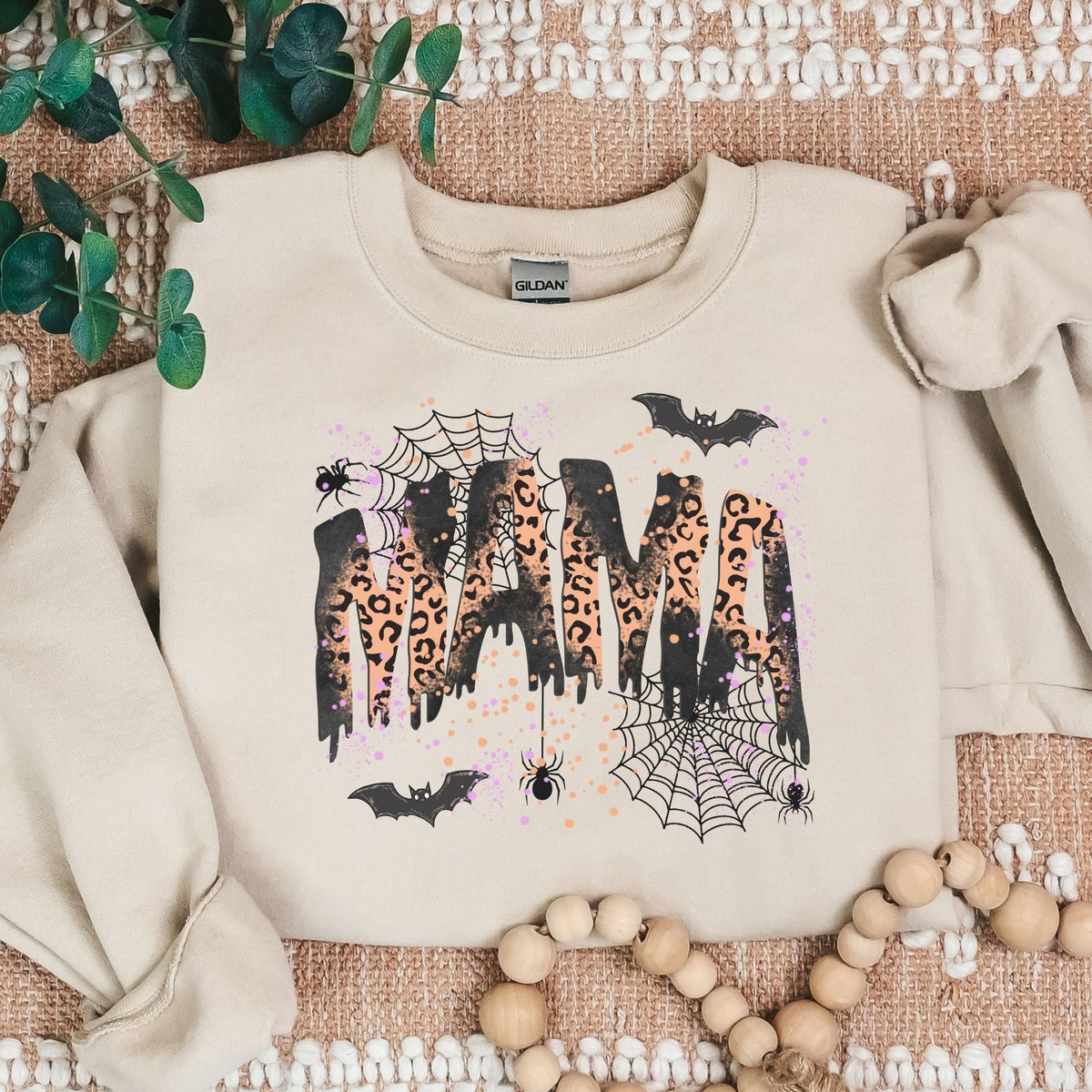 Sand Gildan heavyweight sweatshirt with leopard MAMA Halloween graphic in rustic flat lay