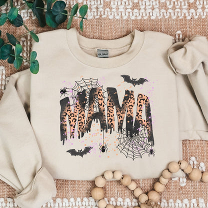 Sand Gildan heavyweight sweatshirt with leopard MAMA Halloween graphic in rustic flat lay