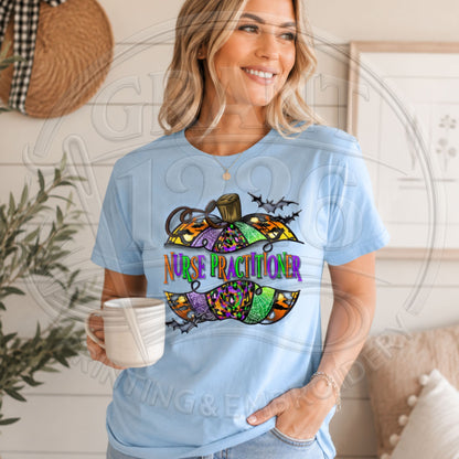 Chambray Comfort Colors short sleeve Nurse Practitioner Halloween shirt with colorful pumpkin and bats graphic, modeled indoors.