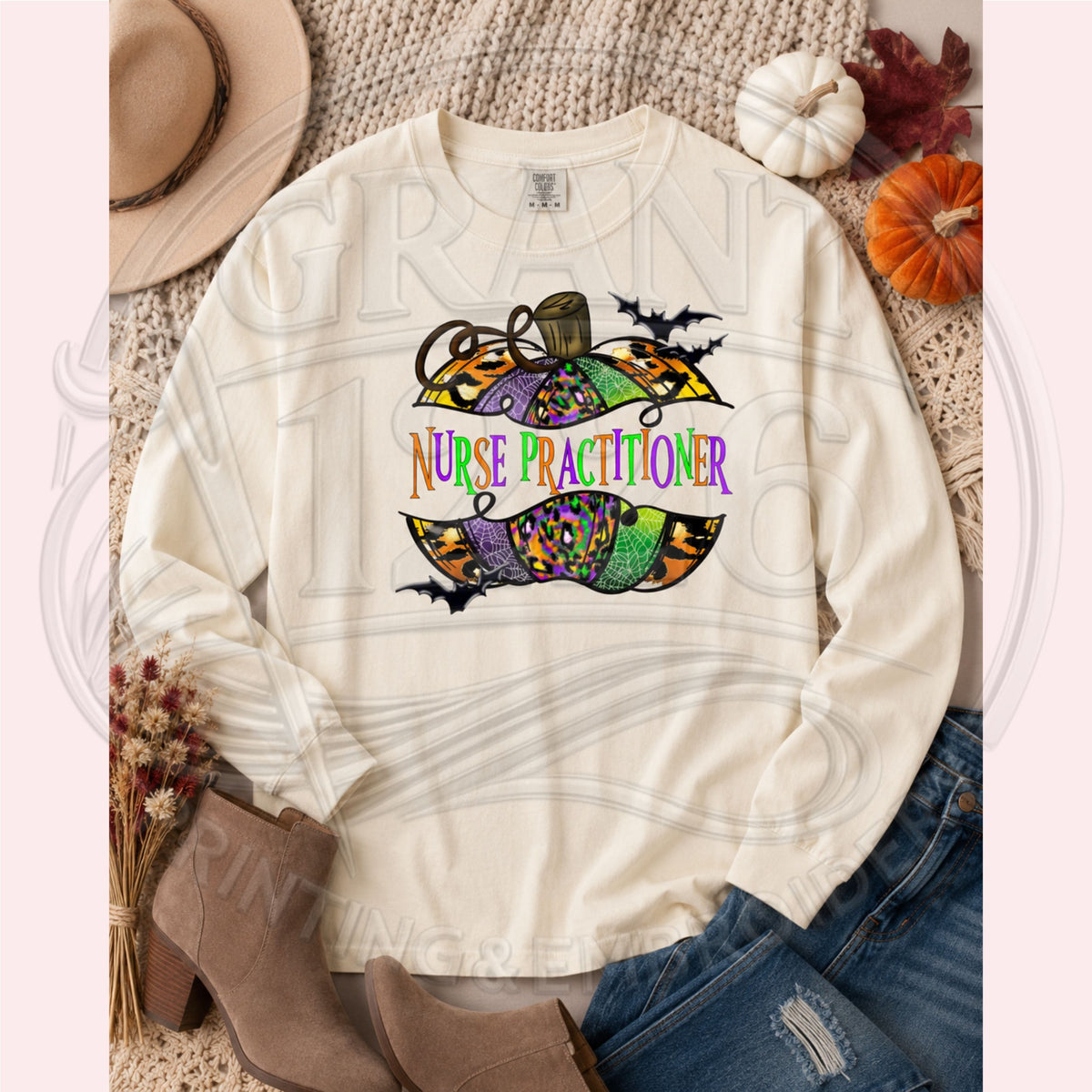 Ivory Comfort Colors long sleeve Nurse Practitioner Halloween shirt with colorful pumpkin and bats graphic, fall flat lay.